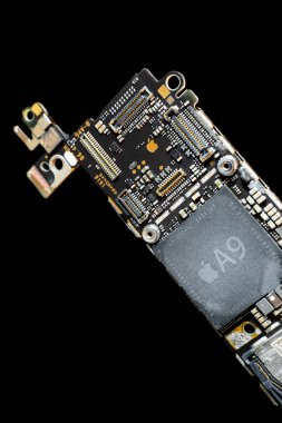 Kyiv, Ukrayna - 25 Ağustos 2023: Elma A9 işlemcili Apple iPhone ana kartı, siyah arka planda yakın plan. Devre kartında altın şirket logosu, dikey fotoğraf.