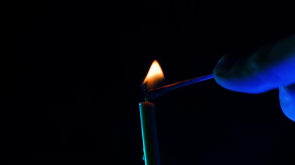 一只手在黑色的背景上用火柴点燃一支蜡烛 在黑暗中吹灭燃烧的蜡烛 高质量的4K镜头 — 图库视频影像