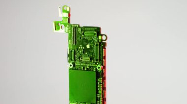 Kyiv, Ukrayna - 6 Ekim 2023: Apple logosu olan eski bir iPhone 'un ana kartı. Parıldayan ışıkları farklı renklerde yakmak. Yüksek kalite 4k görüntü