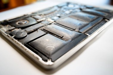 Kyiv, Ukrayna - 17 Ağustos 2023: MacBook Pro Retina dizüstü bilgisayarında şişmiş pil, yakın plan. Eski Apple ekipmanlarının onarımı ve restorasyonu