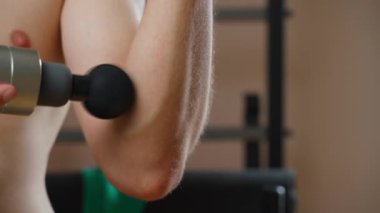 Perküsyon masajcısıyla orta epikondilit tedavisi. Erkekler spor yaptıktan sonra dirsek ağrısı. Yüksek kalite 4k görüntü