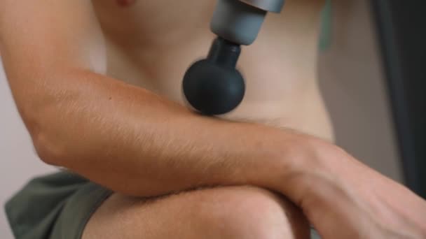 남자가 타악기 마사지기 클로즈업으로 Brachioradialis 근육을 마사지 고품질 — 비디오