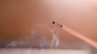 Tütsü, bulanık bir arka planda yakın plan sigara içer. Yüksek kaliteli FullHD görüntüler