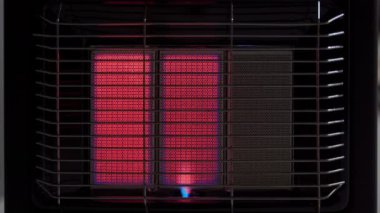 Modern bir gaz ısıtıcısı karanlıkta üçte iki kapasiteyle çalışır, yakın planda. Havalandırması iyi olan bir oda ısıtması. Yüksek kalite 4k görüntü