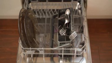 Bir el, kirli bulaşık sepetini bulaşık makinesine itiyor. Yüksek kalite 4k görüntü