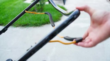 Bir el, çim biçme makinesinin gaz pedalına basar, yakın plan. Yüksek kalite 4k görüntü