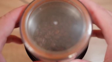 Kahve öğütücüsünde kahve çekirdeklerini öğütme süreci, üst manzara. Yüksek kalite 4k görüntü