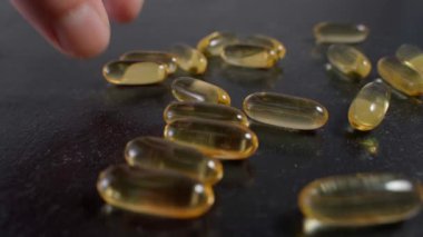 El, Omega 3 kapsüllerini yakın çekim ile topluyor. Yüksek kalite 4k görüntü