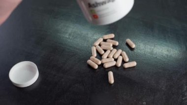 Kyiv, Ukrayna - 4 Ocak 2025: GymBeam 'den Ashwagandha ile plastik kavanoz. Ashwagandha 'nın elindeki kapsülleri boşaltın. Yüksek kalite 4k görüntü