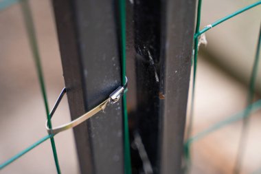 Bulanık arkaplanda tel örgü örmek için demir kravat.