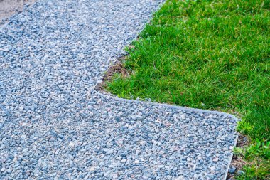Bir ülke arazisinin peyzaj tasarımı. Çakıl, yeşil çimen ve çimen ekmeye hazırlanan toprakla kaplı yollar..