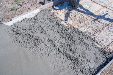 Güneşli bir günde yola beton dökme süreci, yakın plan..