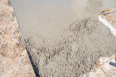 Güneşli bir günde yola beton dökme süreci, yakın plan..