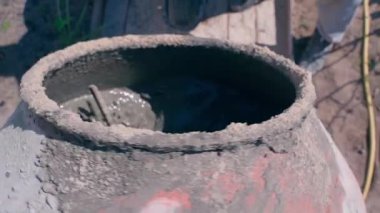 Beton karıştırıcı yavaş çekimde döner, üst görünümde. İnşaat alanında beton karışımı karıştırıyorum. Yüksek kaliteli FullHD görüntüler