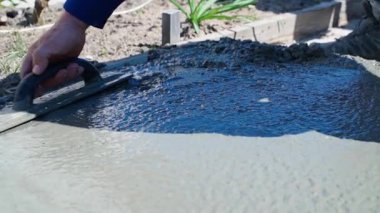 Bir adamın eli bir malayla taze betonu düzleştiriyor. Yüksek kaliteli FullHD görüntüler