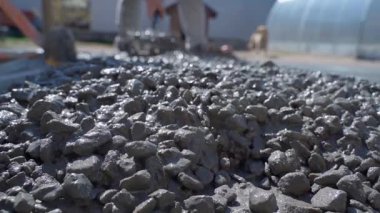 Dökülen beton yolun işleyişi. Beton karışımı, yakın plan, bulanık arkaplan üzerinde çalışan işçi. Yüksek kaliteli FullHD görüntüler
