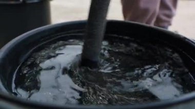 Siyah bir kovanın içinde suyu karıştırmak. Yüksek kalite 4k görüntü