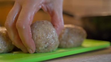 Mutfakta tahta kesmekten çiğ pirzola yiyen kadın, yakın plan. Yüksek kaliteli FullHD görüntüler