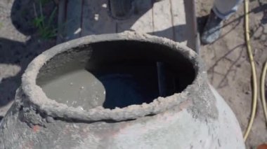Bir kürek dolusu kum döner beton karıştırıcının içine atılıyor, yakın çekim, üst görüş. Yüksek kaliteli FullHD görüntüler