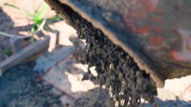 Yavaş çekimde beton karıştırıcıdan beton dökülüyor, yakın plan. Beton bir yol dökme süreci. Yüksek kaliteli FullHD görüntüler
