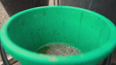Yeşil plastik kovaya su dökerek, yakın plan. Yüksek kaliteli FullHD görüntüler