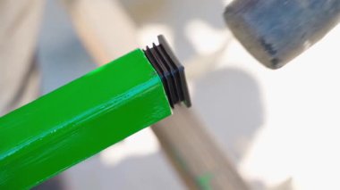Plastik bir fiş kare bir boruya çekiçle sokulur, yavaş çekimde. Yüksek kaliteli FullHD görüntüler