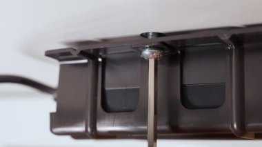 Altıgenle masanın altından plastik bir parçayı vidalamak. Mobilya montajı, yakın plan. Yüksek kalite 4k görüntü
