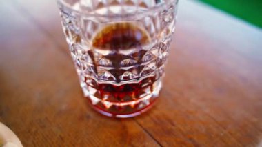 Kamera titrer, sert alkollü kristal bir bardak, yakın plan. Yüksek kalite 4k görüntü