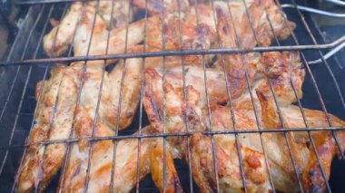 Tavuk kanatları kızartılıyor, ızgaraya yakın çekim yapılıyor. Yüksek kaliteli FullHD görüntüler