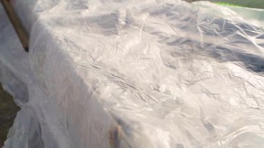 Serada bir yatağı plastik ambalajla kaplamak, yakın plan. Yüksek kaliteli FullHD görüntüler