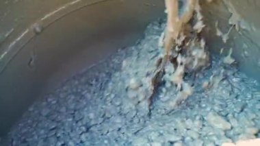Beton karıştırıcının içine taze beton karıştırılır, yavaş çekimde yakın plan. Yüksek kaliteli FullHD görüntüler
