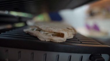Elektrikli ızgarada Pita ekmeği içinde shawarma pişirmek, yakın çekim. Yüksek kaliteli FullHD görüntüler