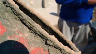 Bir inşaat işçisi beton karıştırıcının arkasında duruyor, yakın plan. Yüksek kaliteli FullHD görüntüler