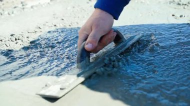 Taze betonu doldurup düzleştiriyor, yakın plan. Bir adamın elinde sıvı beton seviyesinde mala var. Yüksek kaliteli FullHD görüntüler
