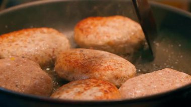 Tahta bir spatula pirzolaları kızartma tavasında yavaş çekimde döndürmek için kullanılır. Yüksek kaliteli FullHD görüntüler