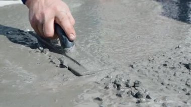 Bir adamın eli beton bir perdeyi malayla dümdüz ediyor, yavaş çekimde yakın çekim. Yüksek kaliteli FullHD görüntüler