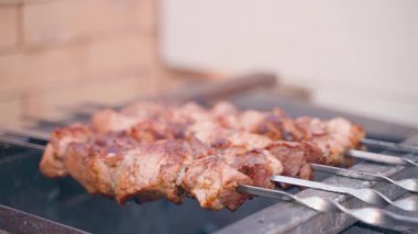 Izgaranın üzerinden yuvarlanan domuz eti şişlerine yakın çekim. Barbekü yapıyorum. Yüksek kaliteli FullHD görüntüler