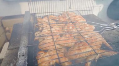 Tavuk kanatlarının ızgara edilişine düzgün kamera yaklaşımı, yakın plan. Yüksek kaliteli FullHD görüntüler