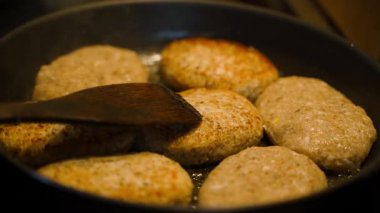 Pirzolalar tavada kızartılır. Dönmek için ahşap bir spatula. Yüksek kalite 4k görüntü