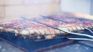 Tavuk butları ızgarada kızartılır, dumanla kaplanır, yakın plan. Yüksek kalite 4k görüntü