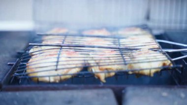 Tavuk butları ızgarada kızartılır, yakın plan. Dumanlı et pişiriyorum. Yüksek kalite 4k görüntü