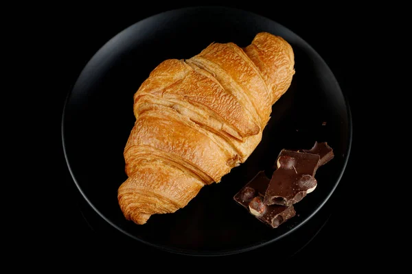 Croissant Mit Schokoladenstücken Auf Einem Schwarzen Teller Ansicht Von Oben — Stockfoto