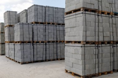 Paletlerin üzerine köpük bloklama malzemesi. Bir paletin üzerinde üst üste yığılmış gaz blokları. Otoklavye ile havalandırılmış beton duvar panelleri açık hava deposunda.