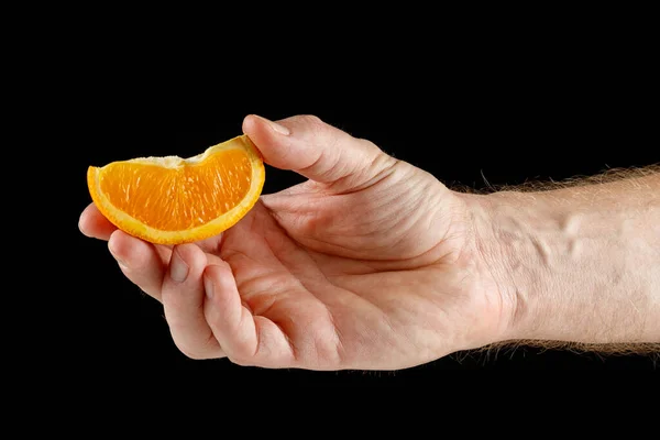 Кусок Апельсина Руке Изолирован Черном — стоковое фото