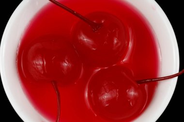 Beyaz fincan içinde kokteyl vişnesi..