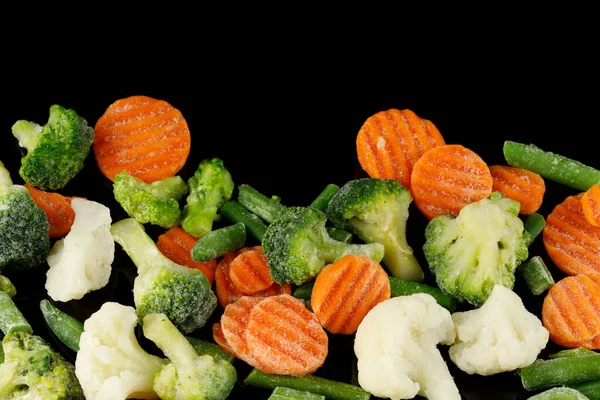 在黑色食物上的冷冻蔬菜特写 免版税图库图片