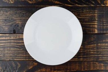 Ahşap zemin üzerinde boş beyaz tabak