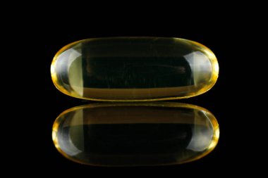 Omega 3 one yellow capsule on black