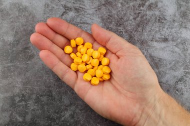 Elinde B grubu vitaminleri olan tabletler