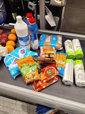 LVIV, UKRAINE - 25 Mart 2024: Checkout Conveyor Belt 'te Çeşitli Bakkaliye